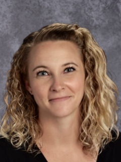 headshot of a woman with blonde curly hair smiling.