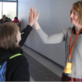 teacher and student hi fiving in the hallway