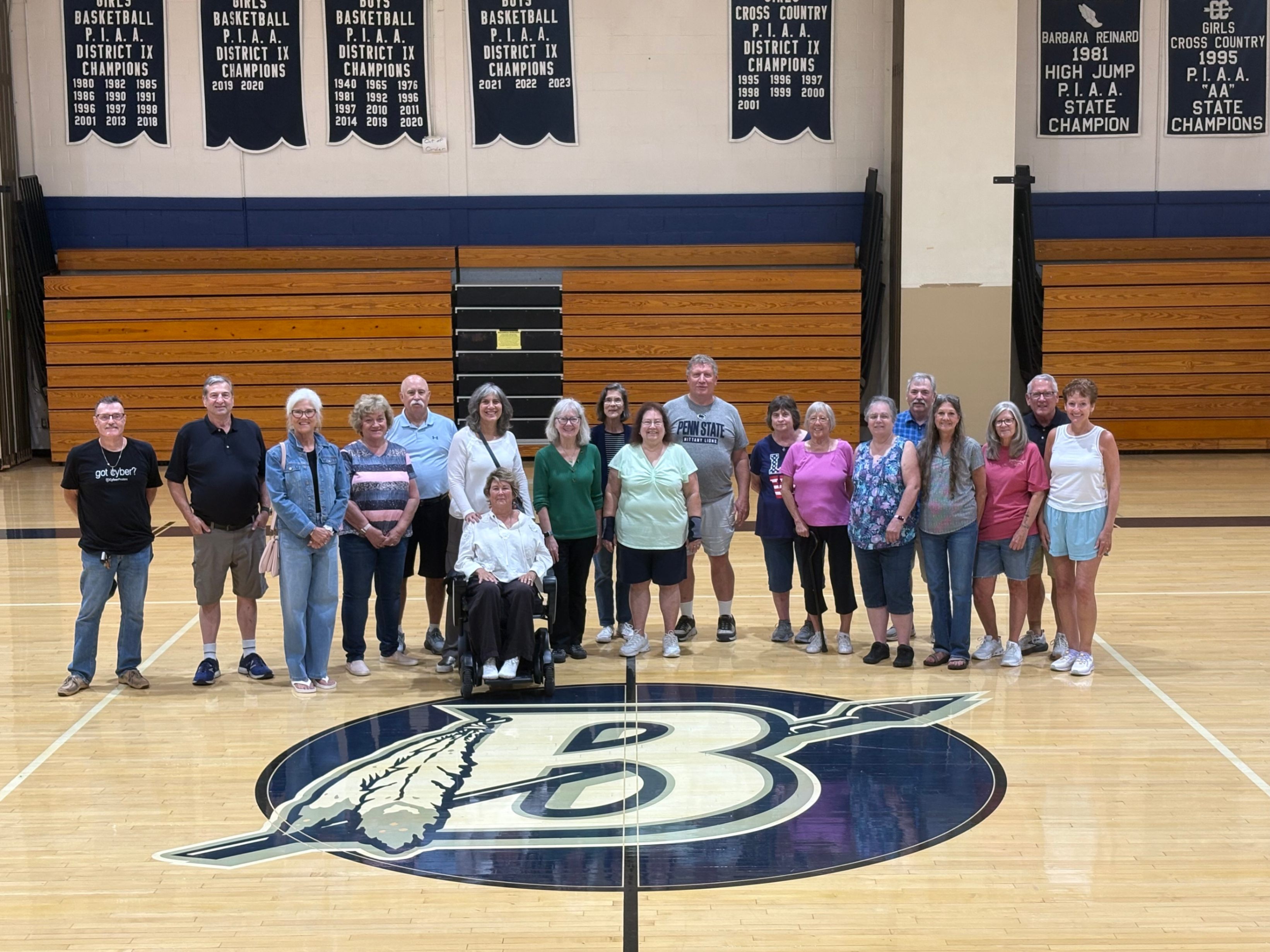 Several members of the BAHS Class of 1976 pose for a photo a mid court in the gymnasium at Brookville High School.