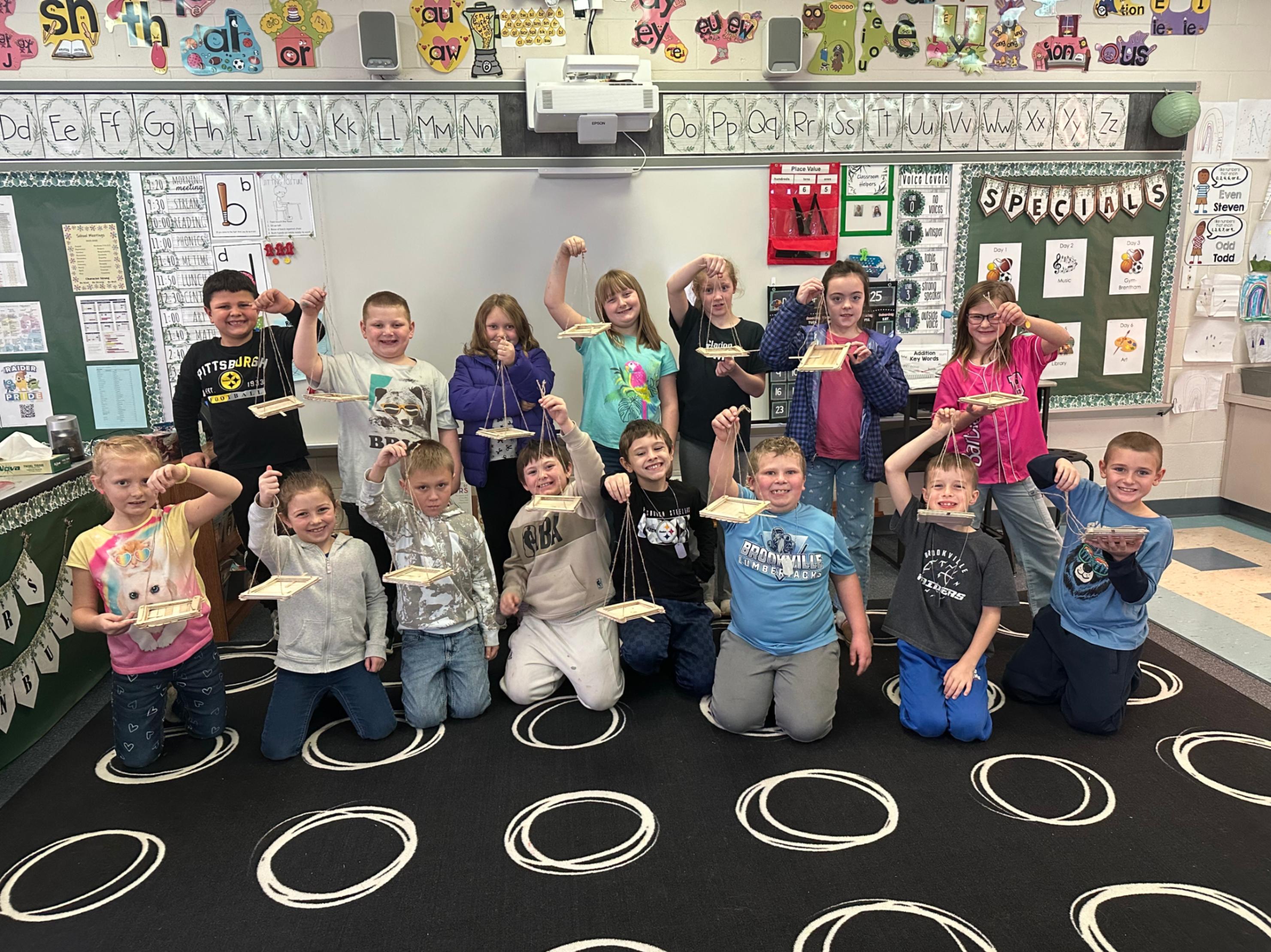 Students at Pinecreek show the bird feeders that they made recently.