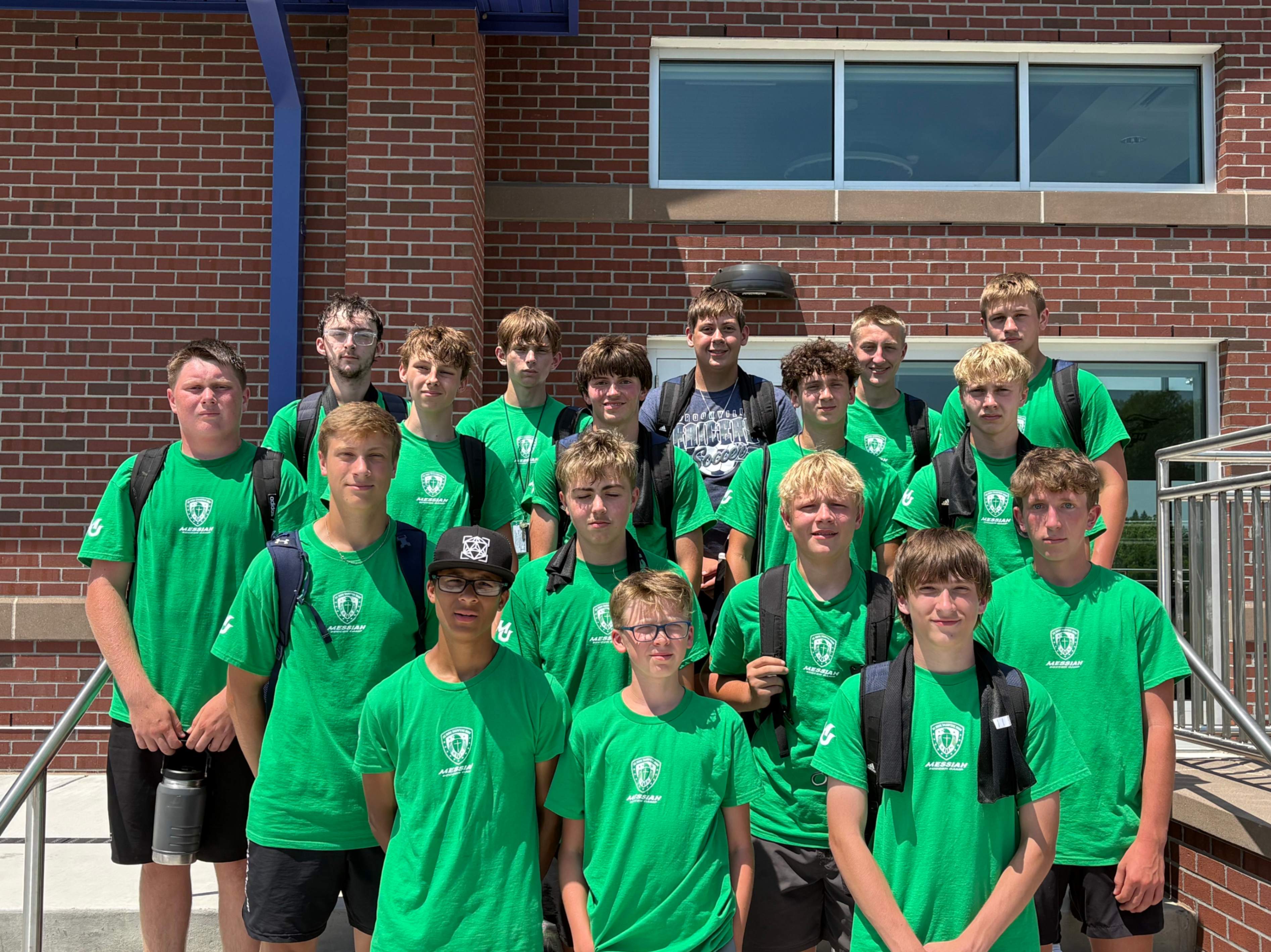 A group of Brookville soccer players pose for a photo outside of a building at Messiah University while attending soccer camp.