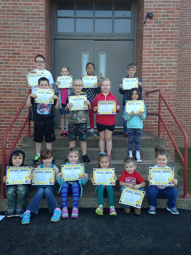 Students pose on stairs holding "Student of the Month" certificates.