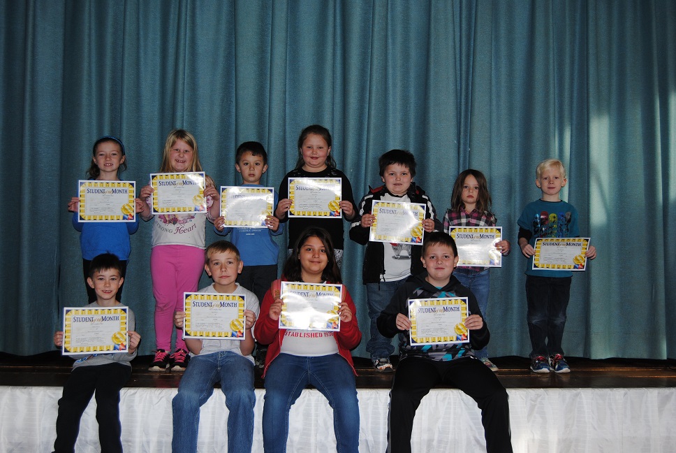 Students pose with certificates on stage.