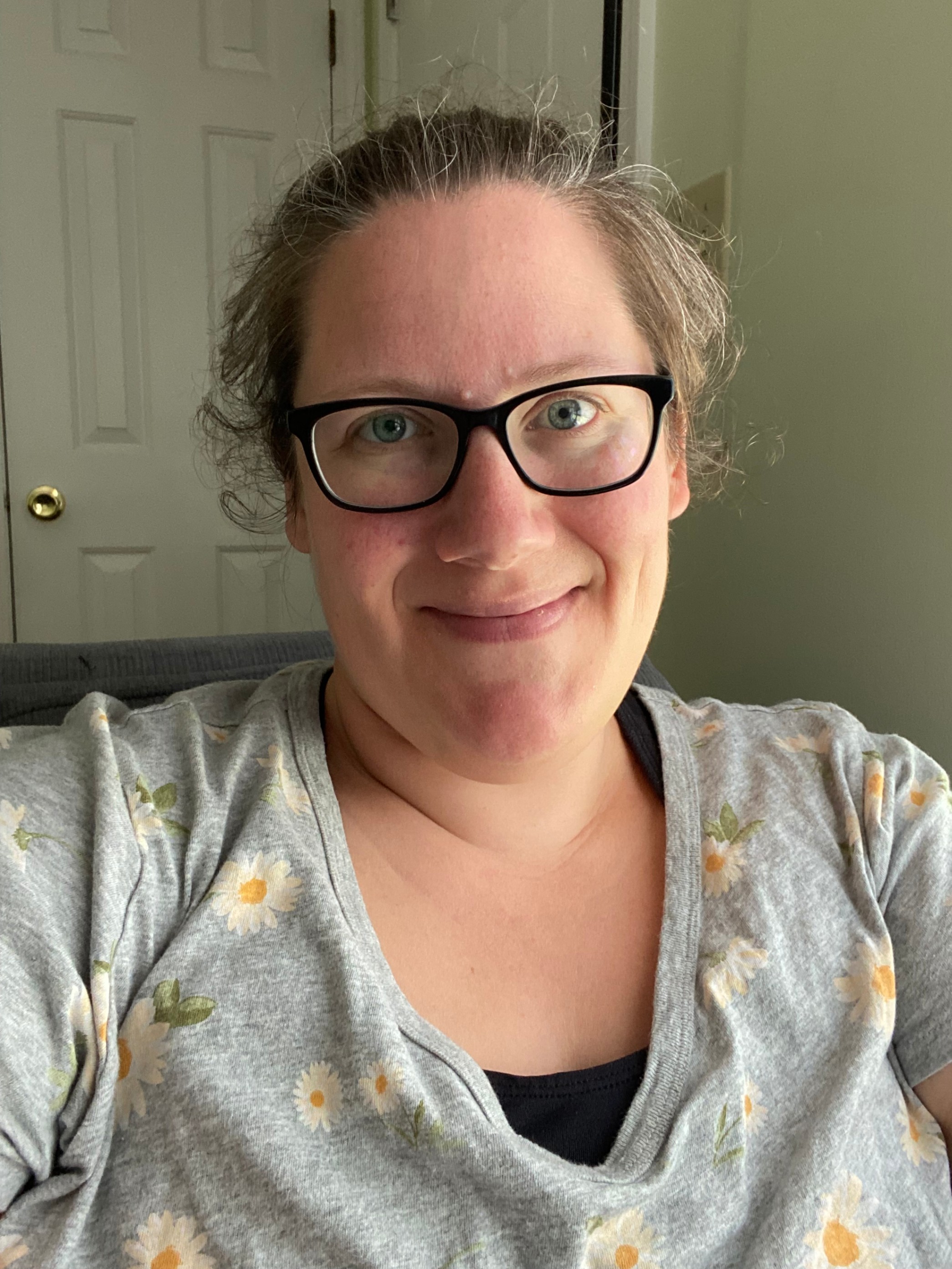 smiling lady with glasses and curly hair 