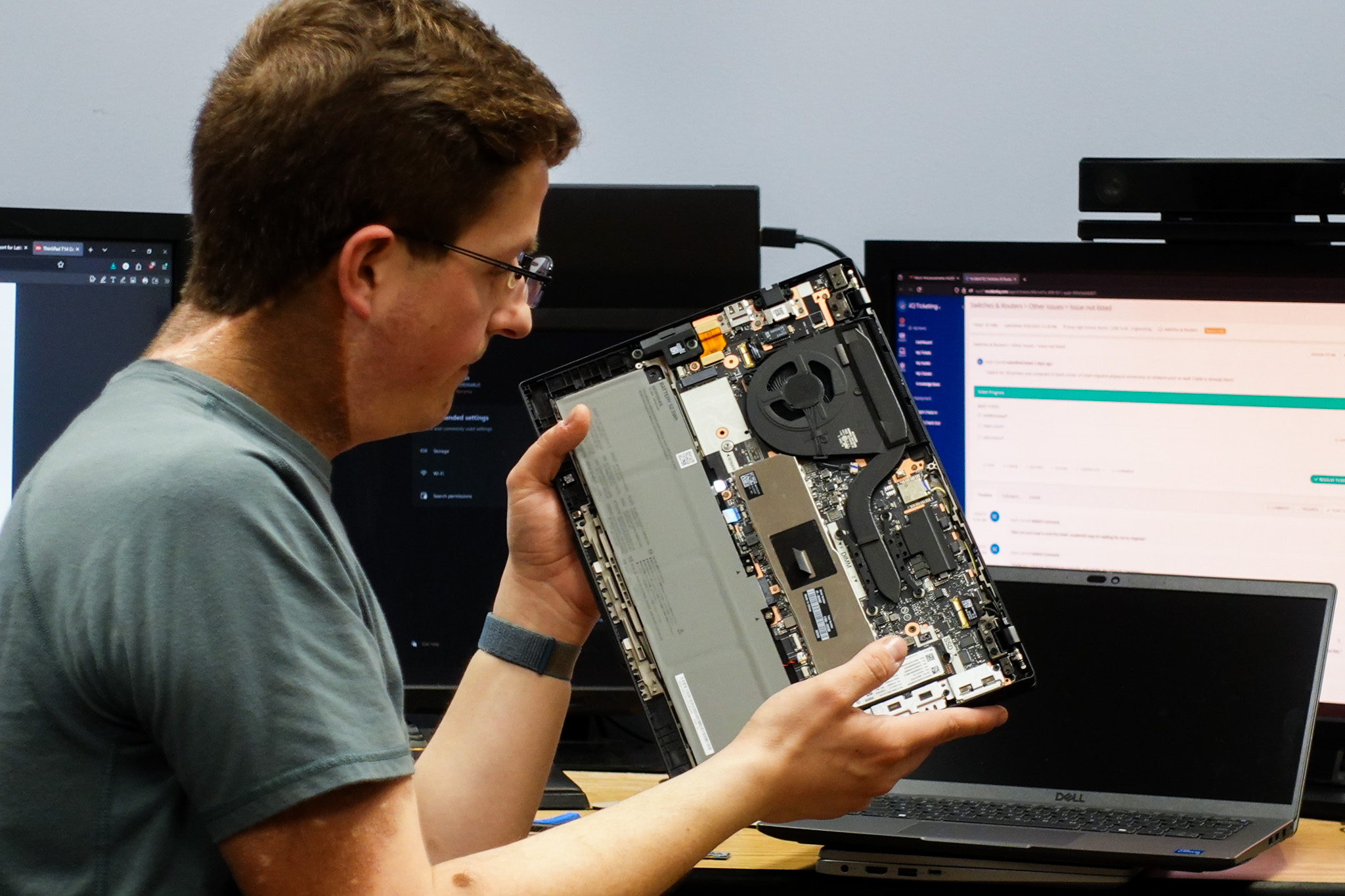 IT staff inspects a new computer before issueing it to a staff member
