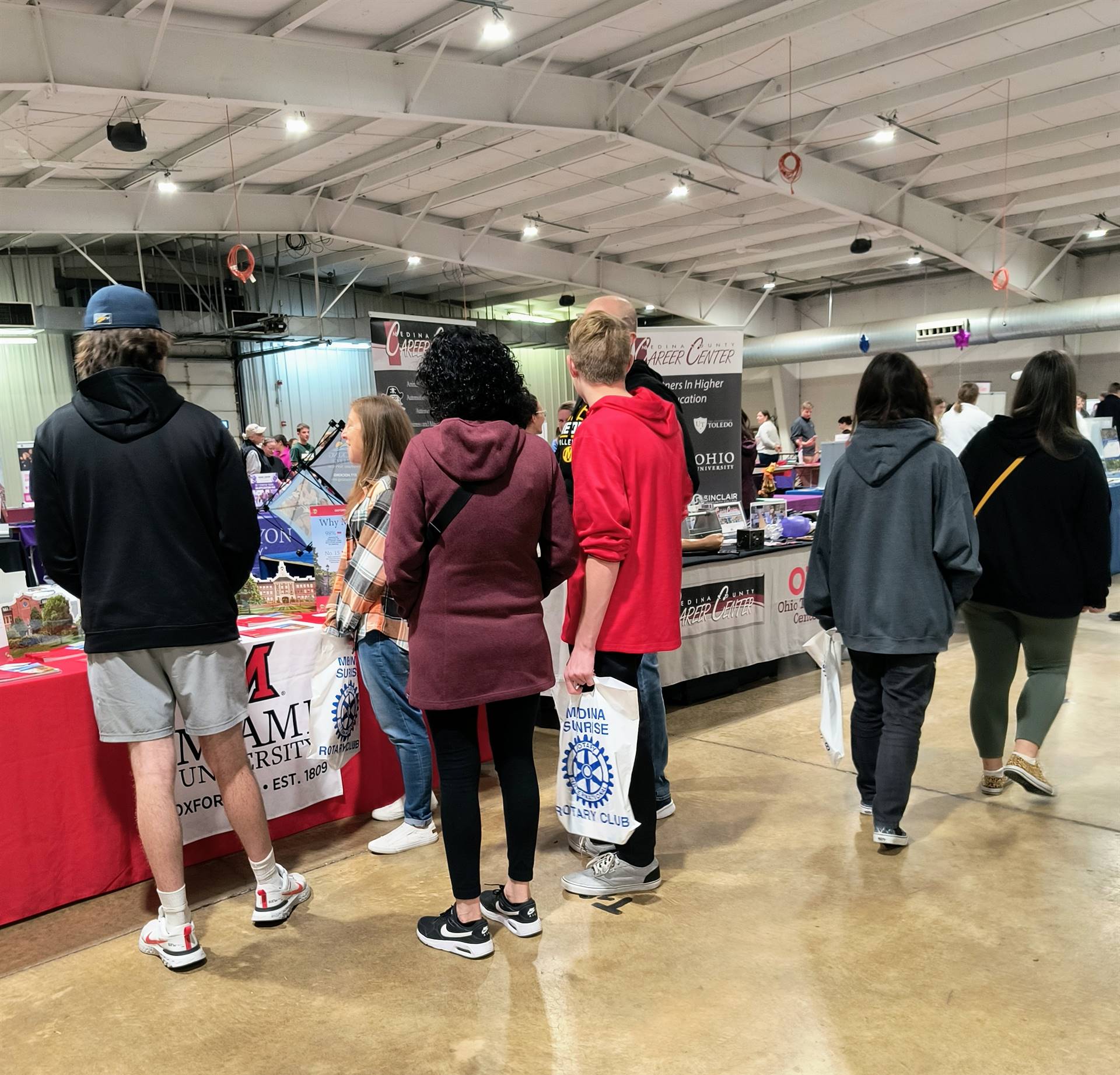 Wide shot of college fair with students walking amongst booths