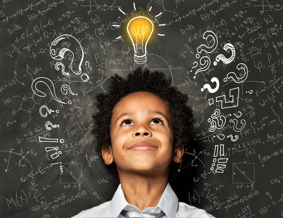 Student with a chalkboard background with a light bulb that is "on" drawn on top of the students head.