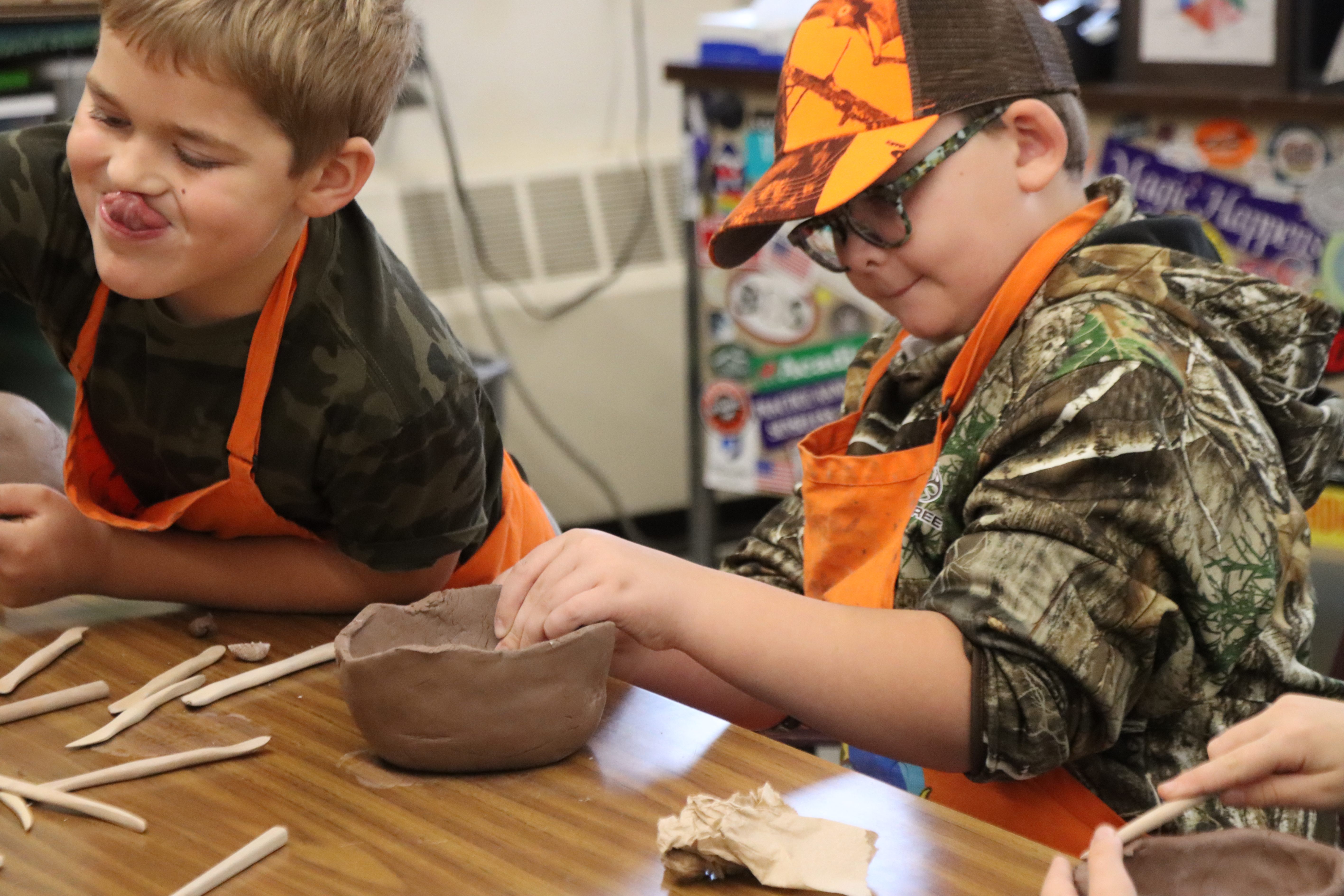 students molding clay bowls