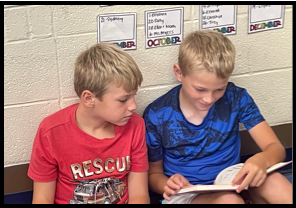 Two boys reading a books