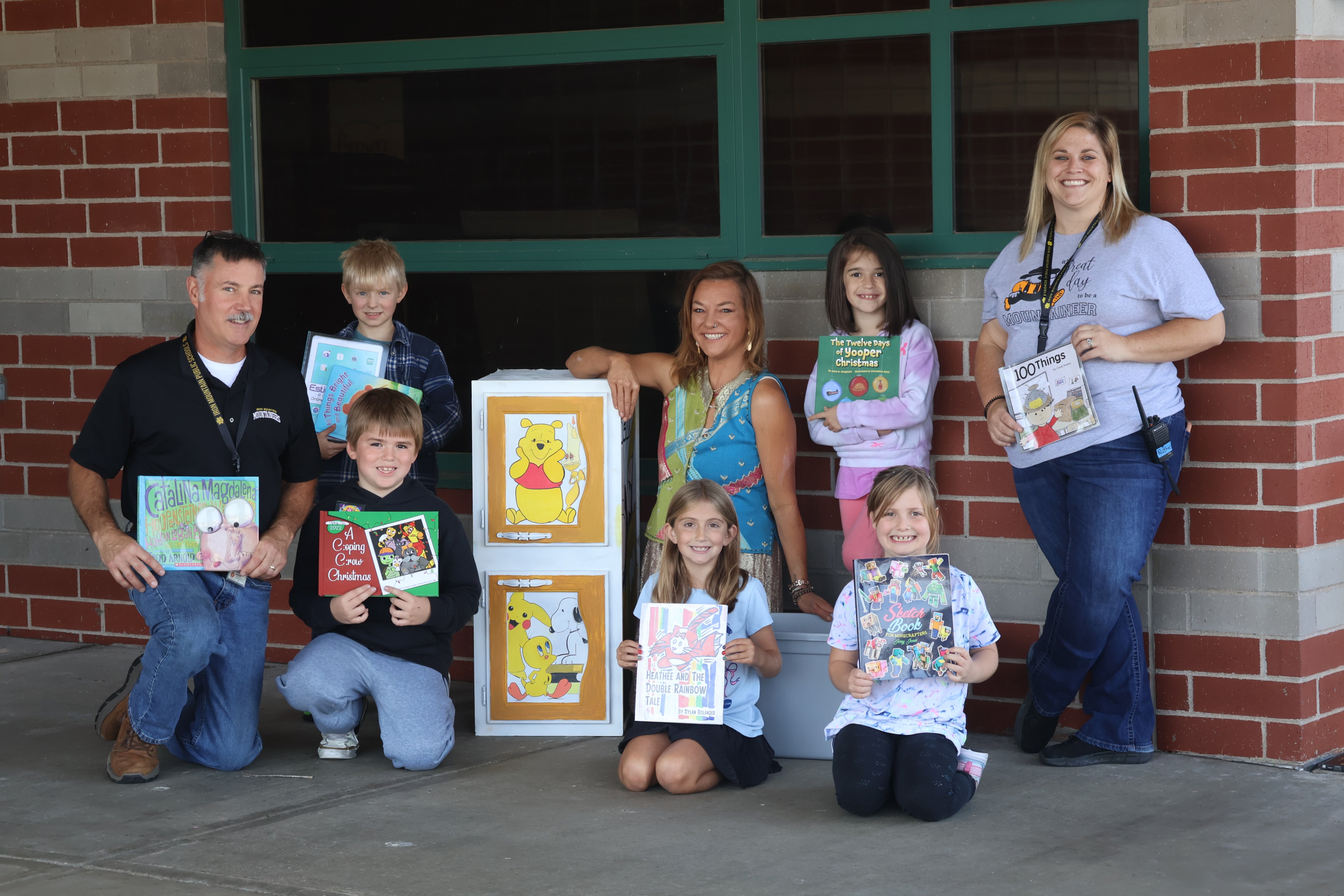 students surrounding Little Library with school staff and Lynne Lillge