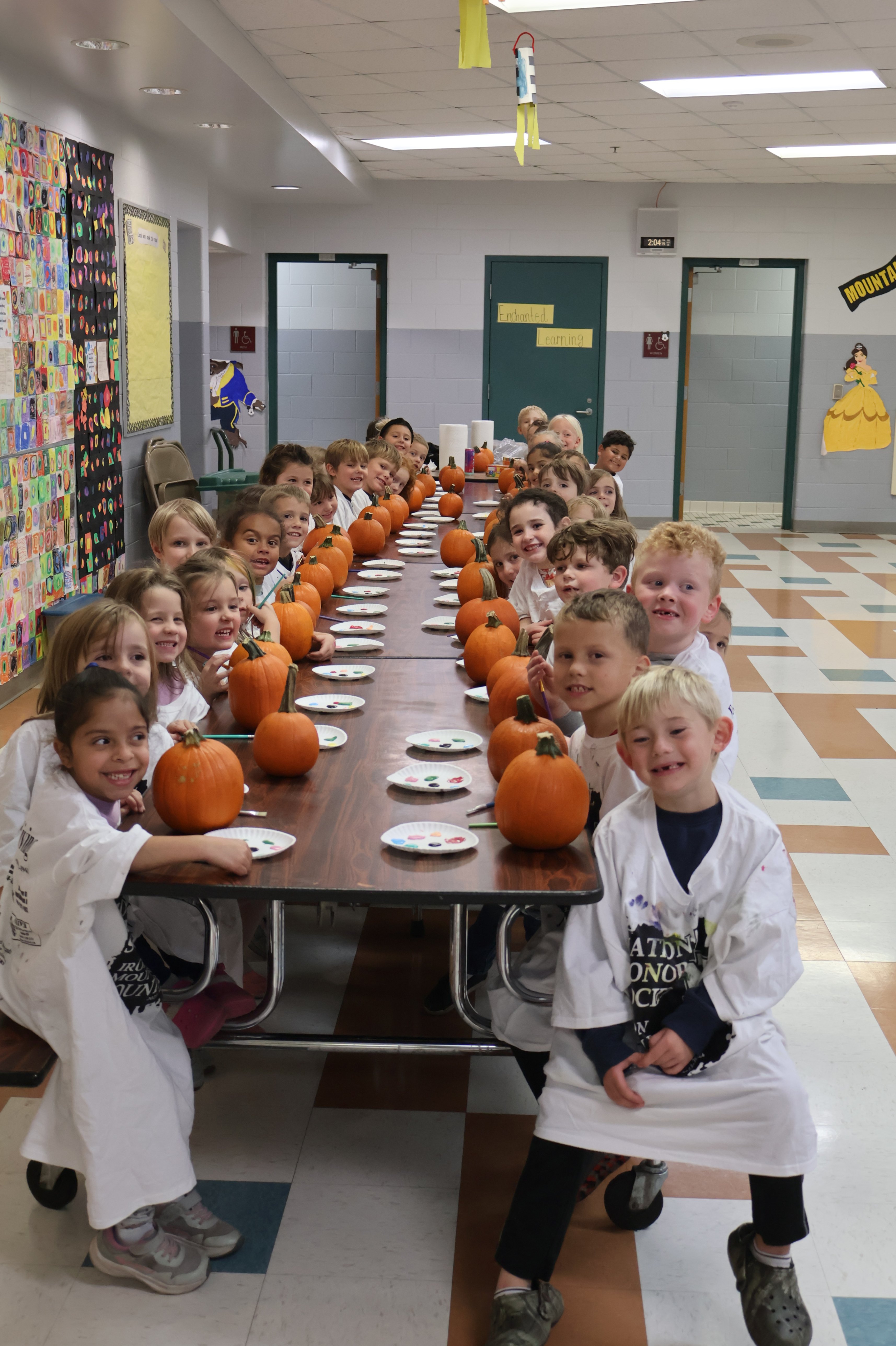 children sitting at table with pumpkins