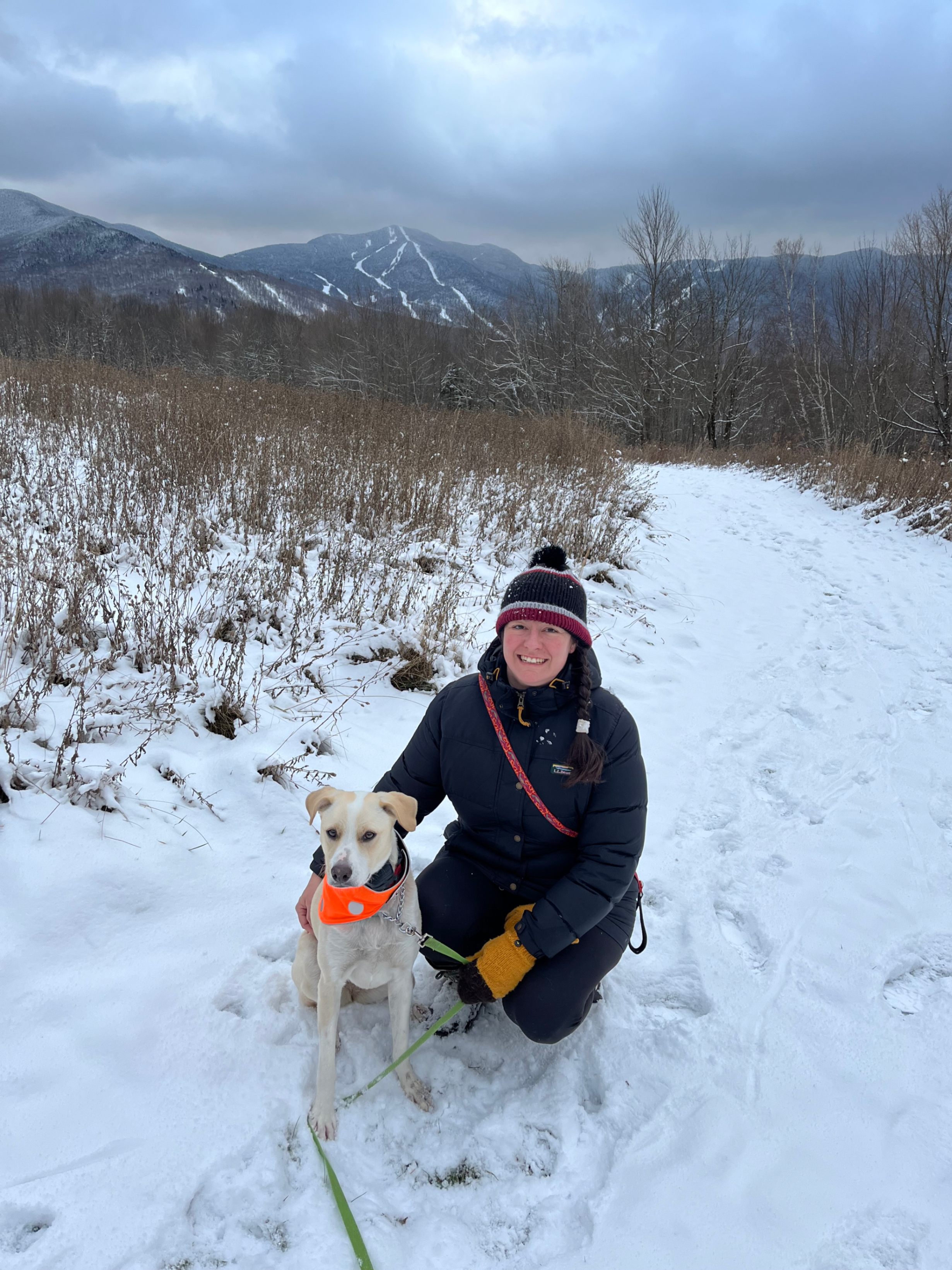 woman hiking with her dog in the snow