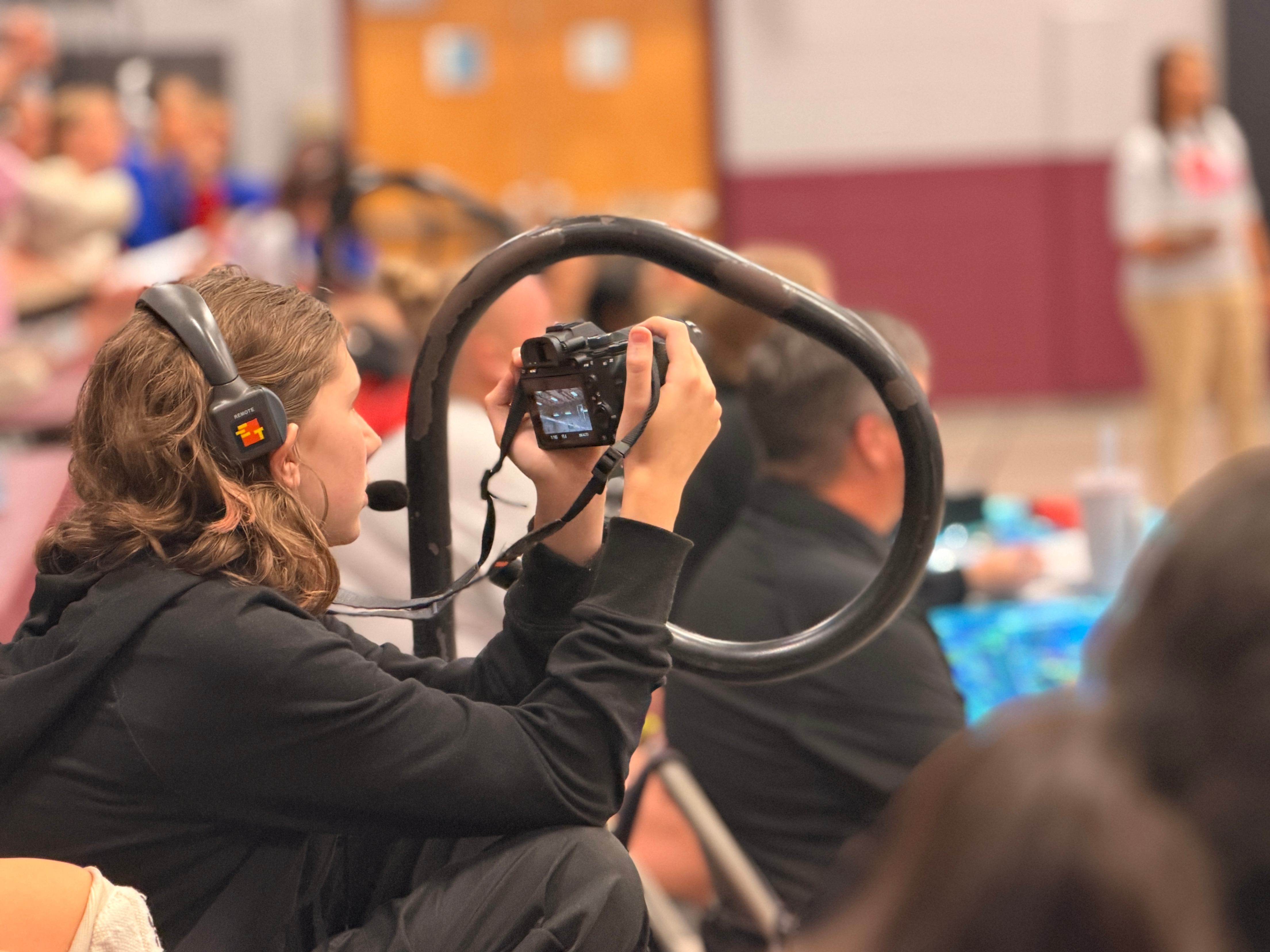 Student taking pictures at middle school volleyball game