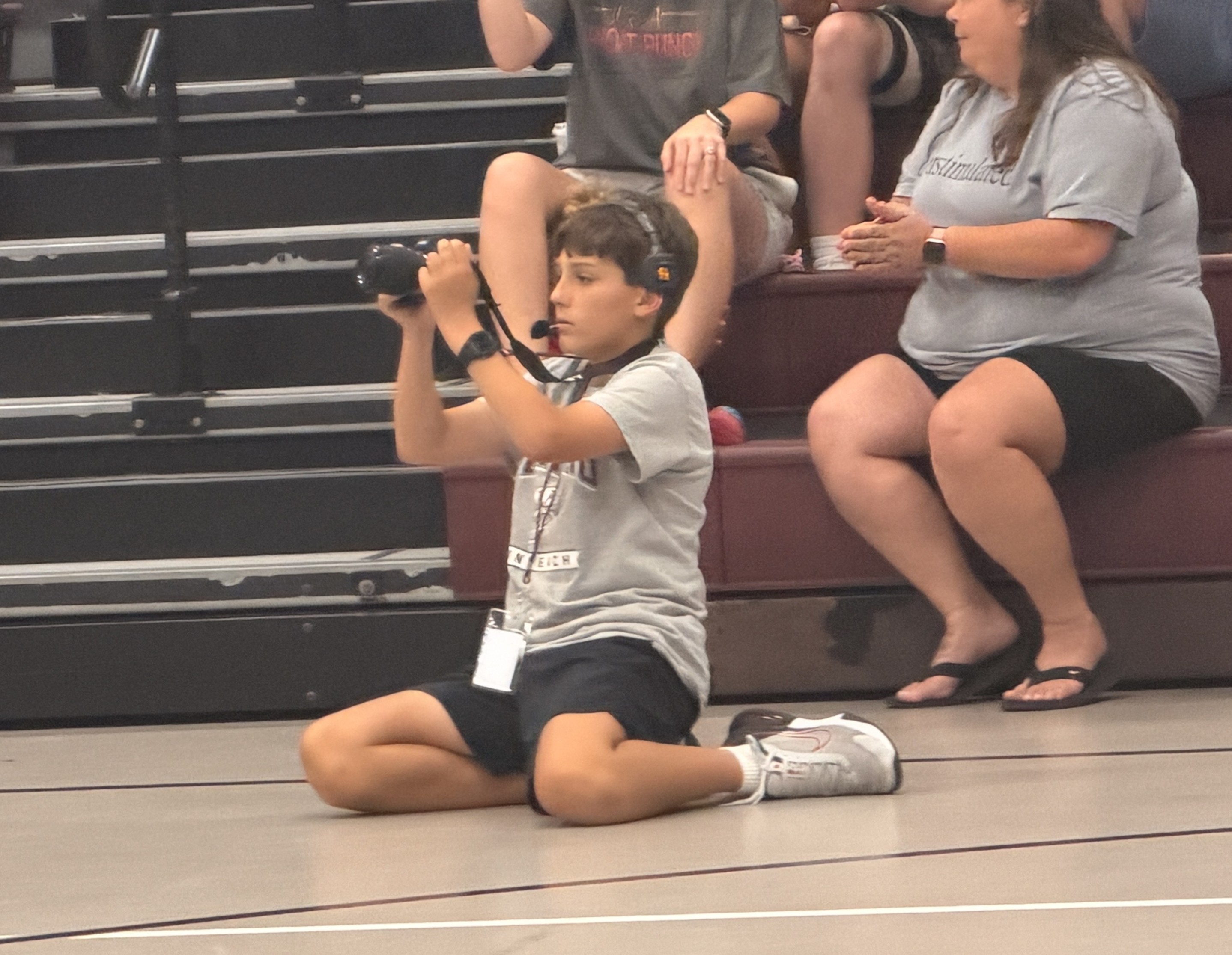 Student taking pictures at middle school volleyball game