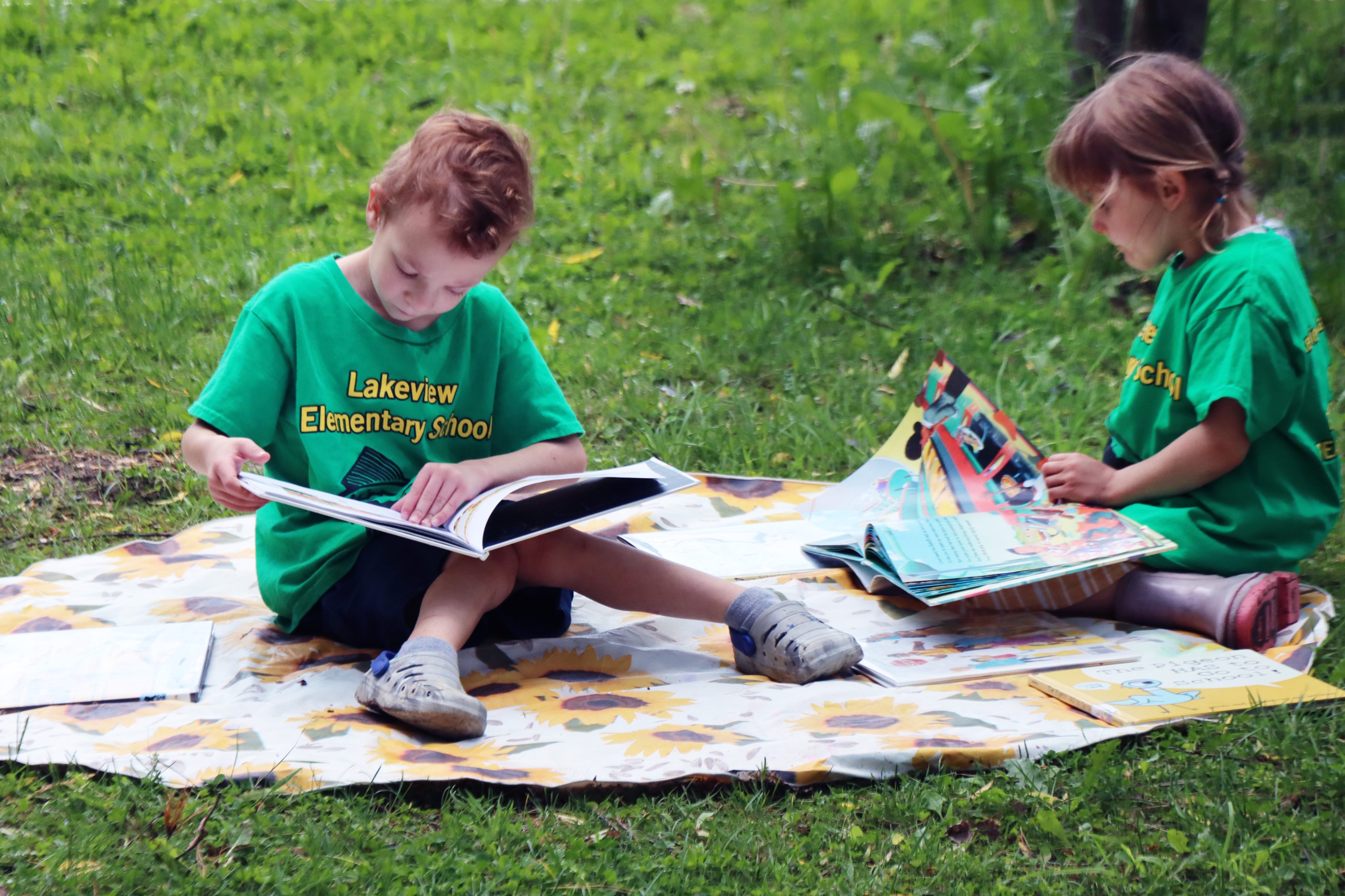 preschool students engaging with books outdoors