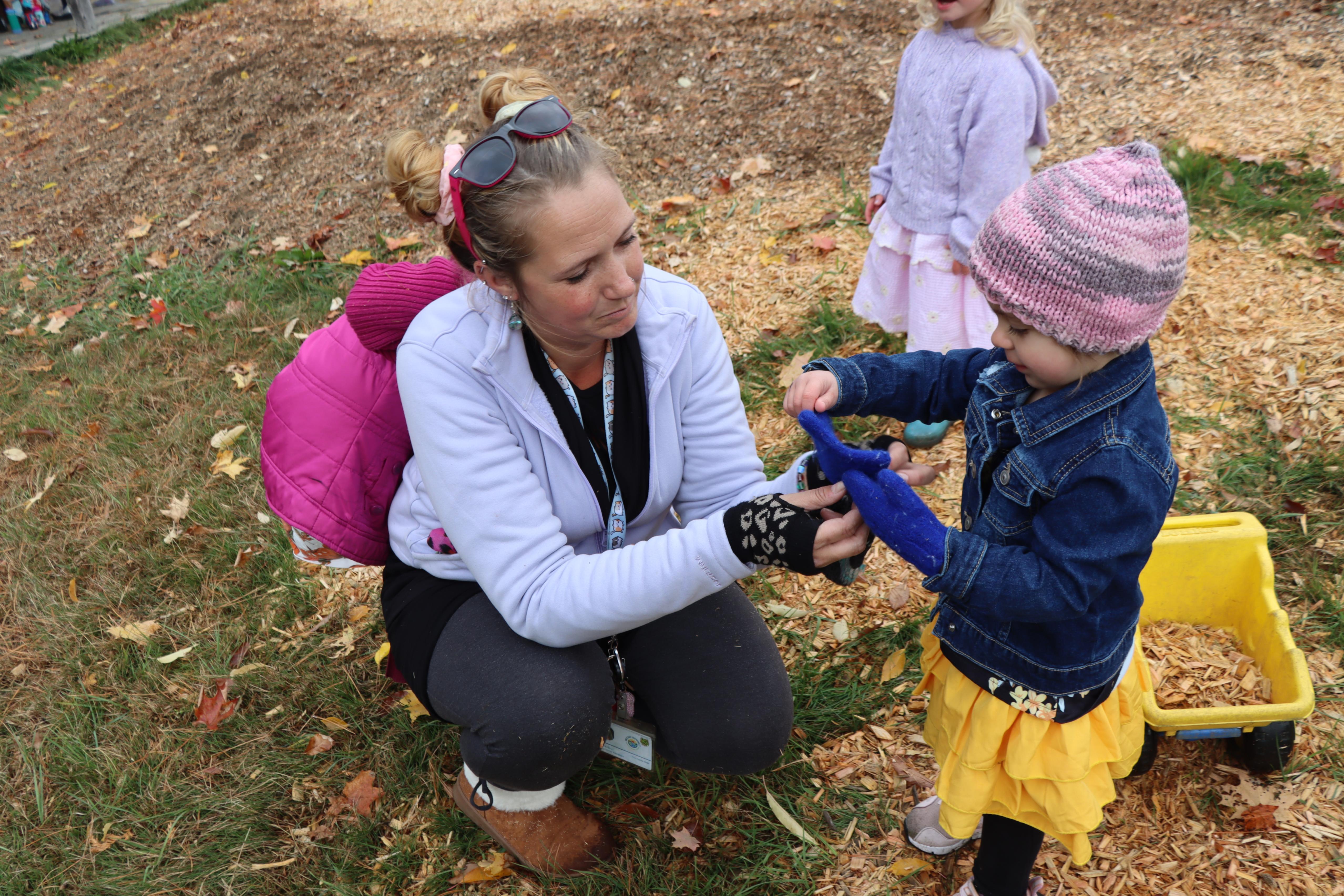 Teacher helping student with mittens
