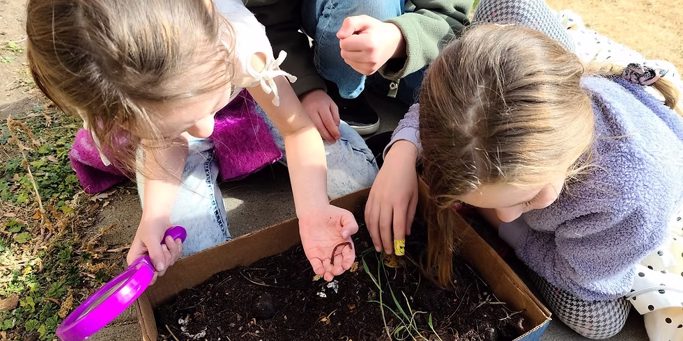 Preschool students examining a box of dirt