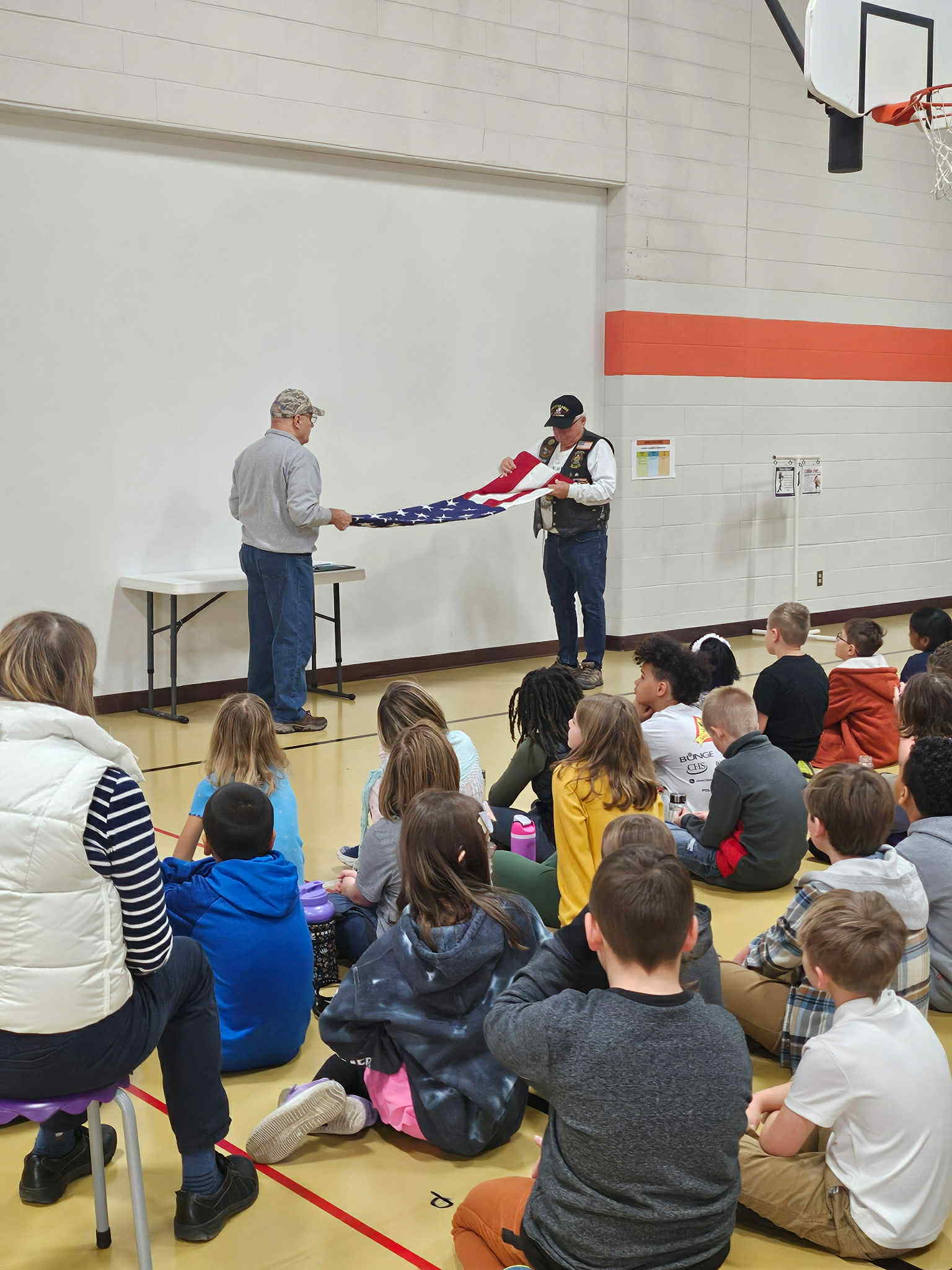 4th grade students watch as an American Flag is folded