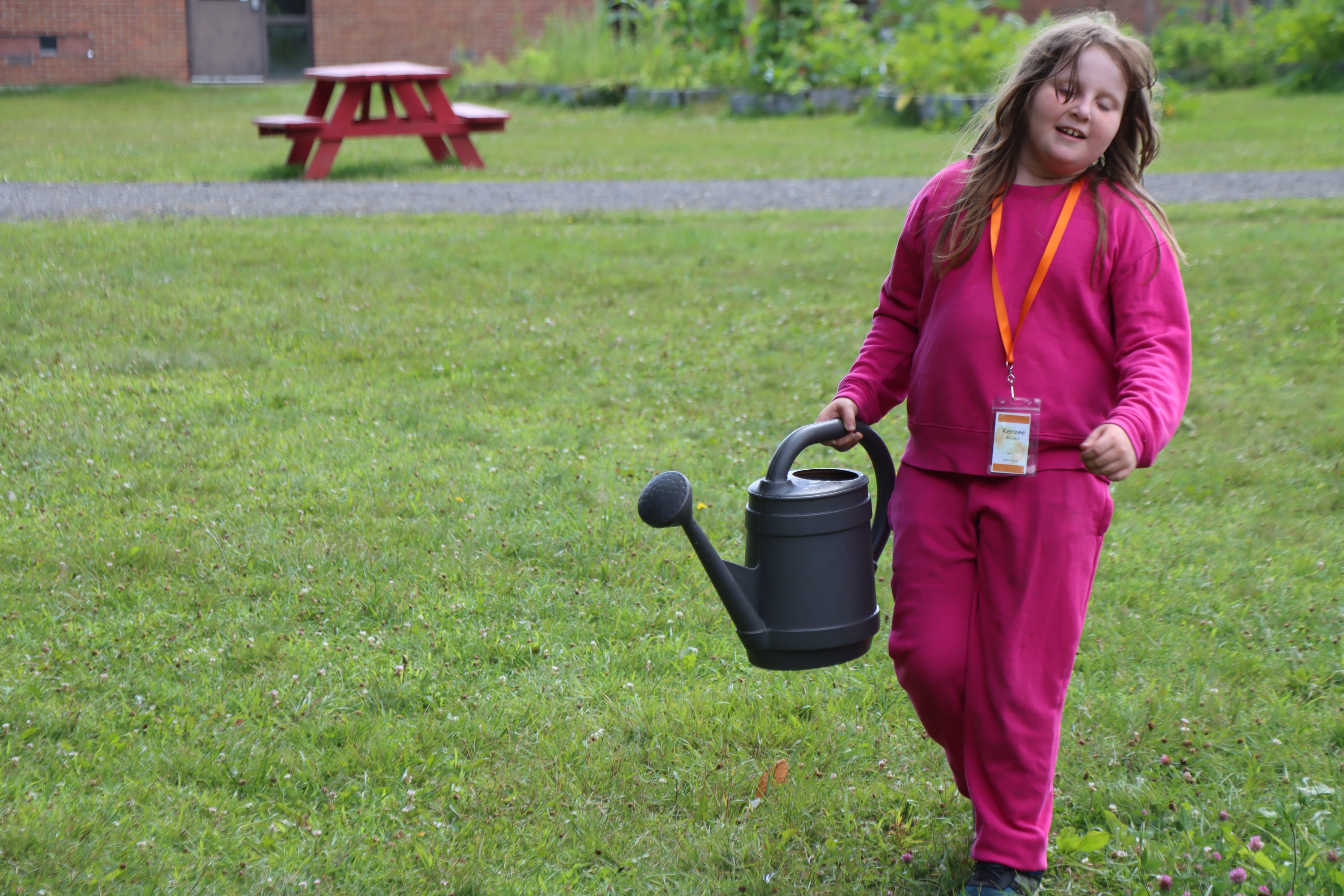 camper hauling watering can to the vegetable garden