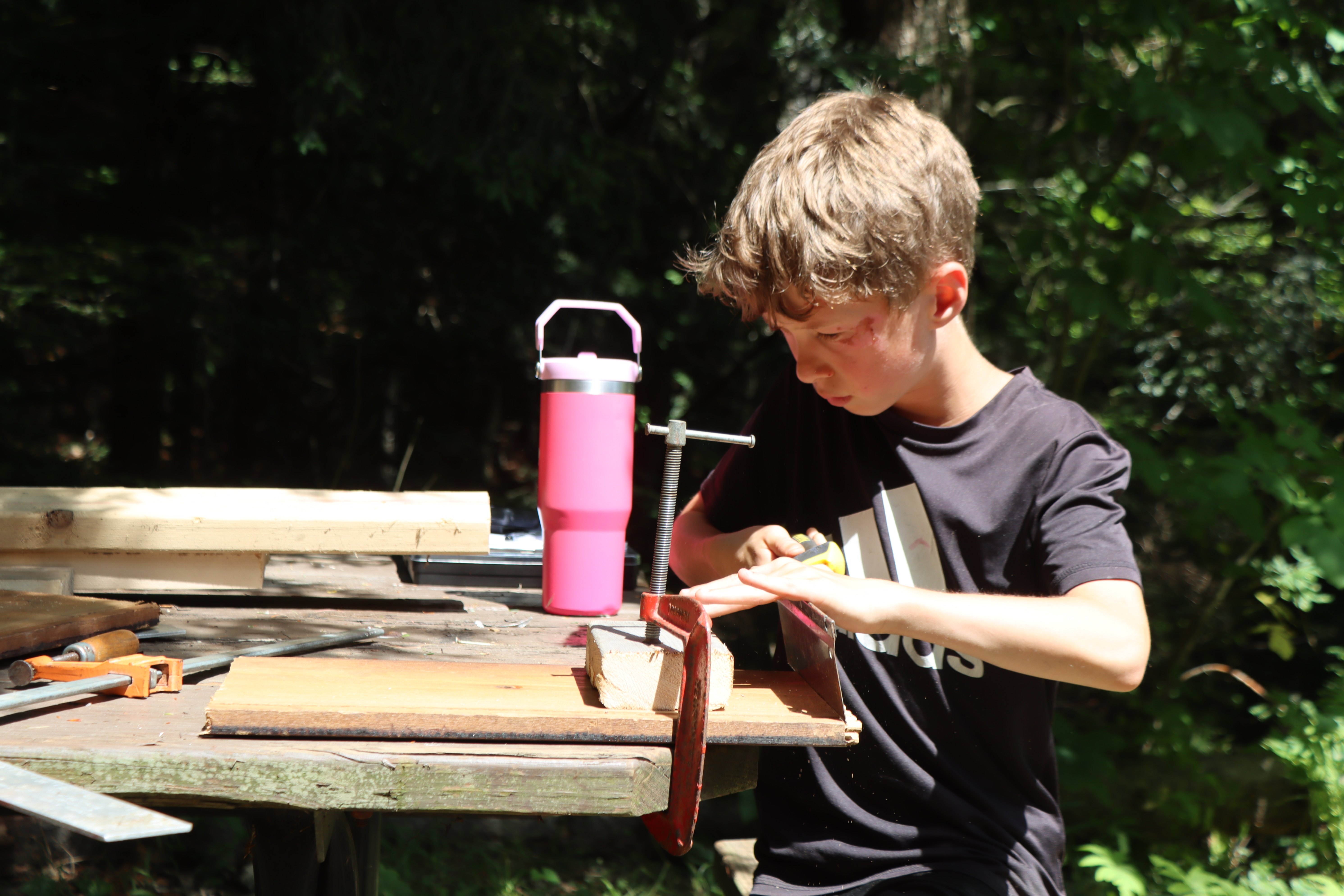 camper building a stool during woodworking
