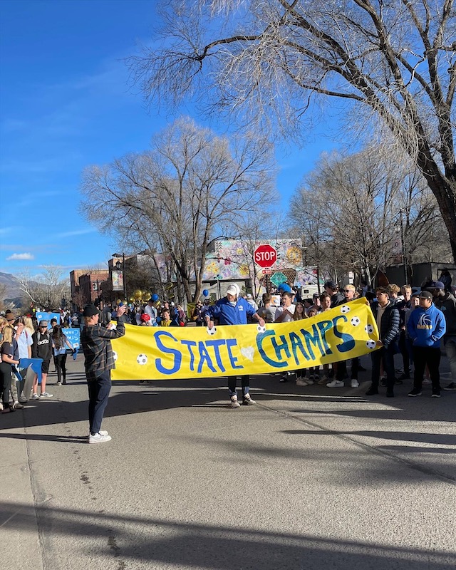 "State Champs" banner being carried down a street