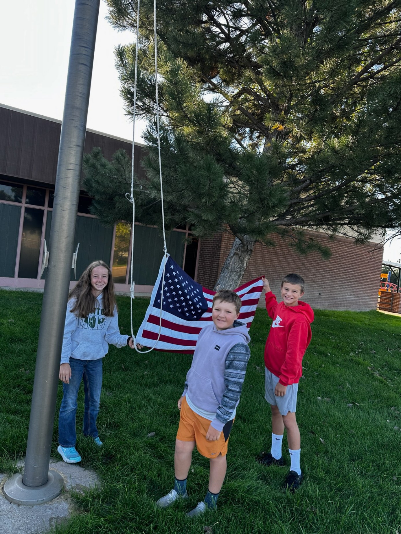 5th Grade students raising the American Flag in front of the elementary school.