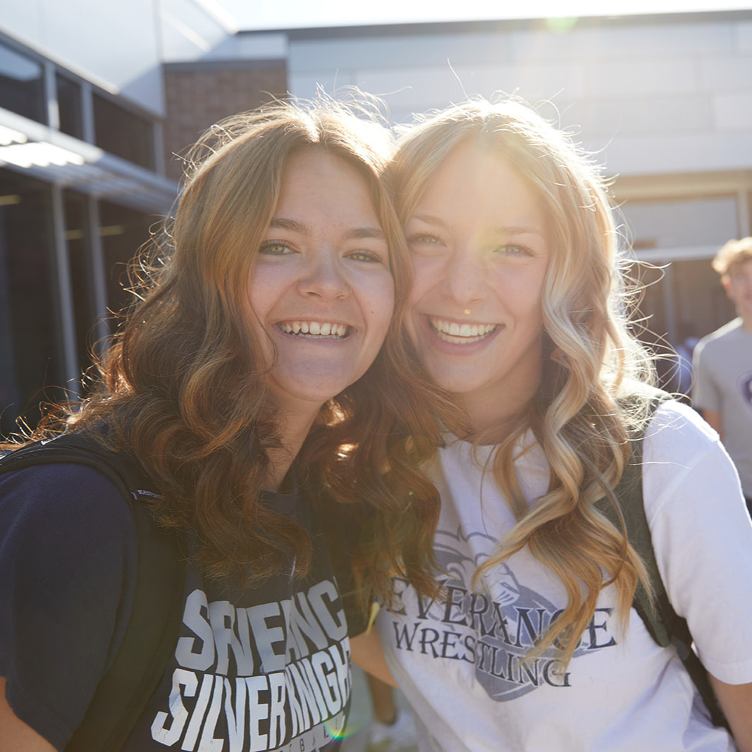 Two female students standing in front of Severance High School smiling