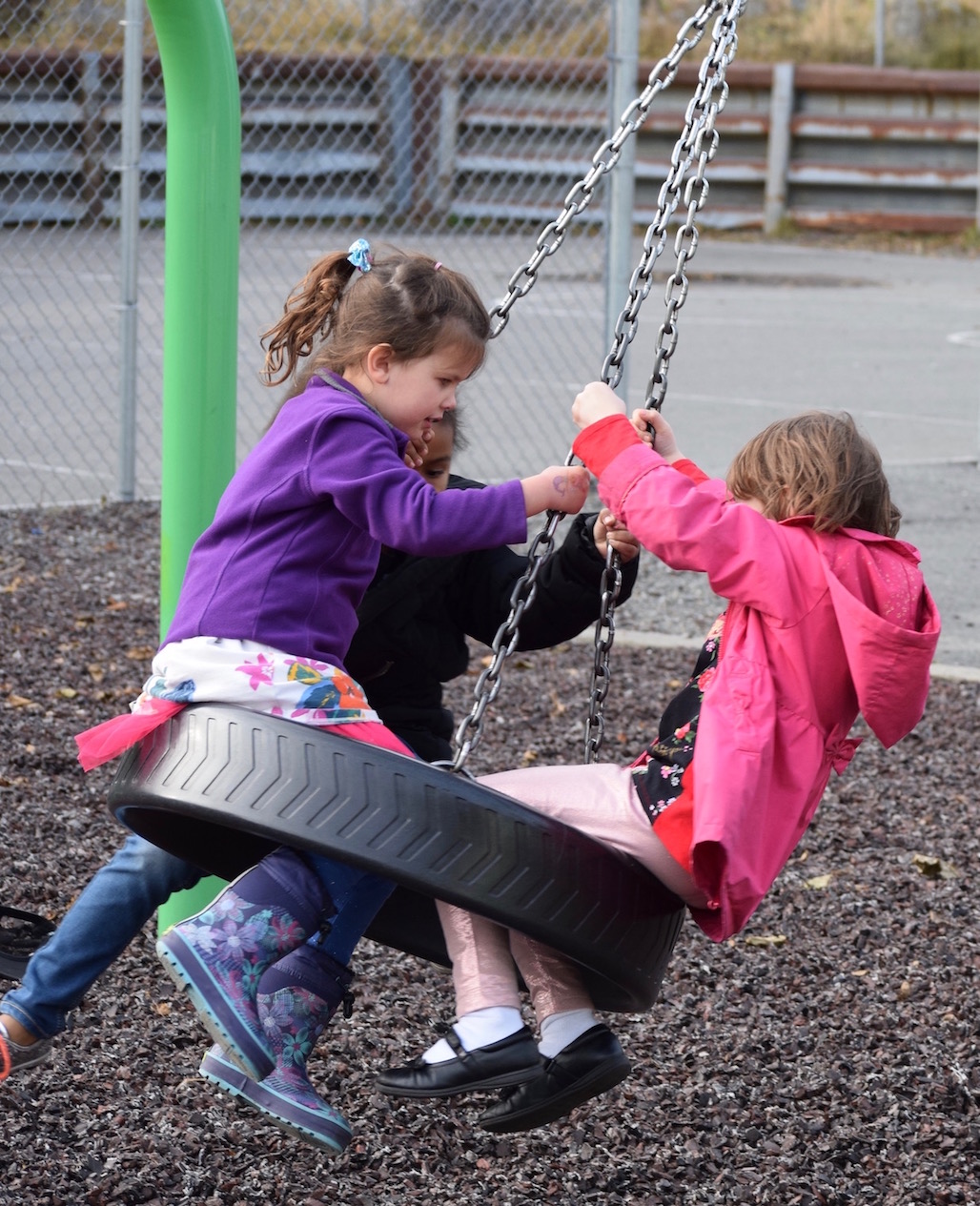 Students playing on the tire swing during recess
