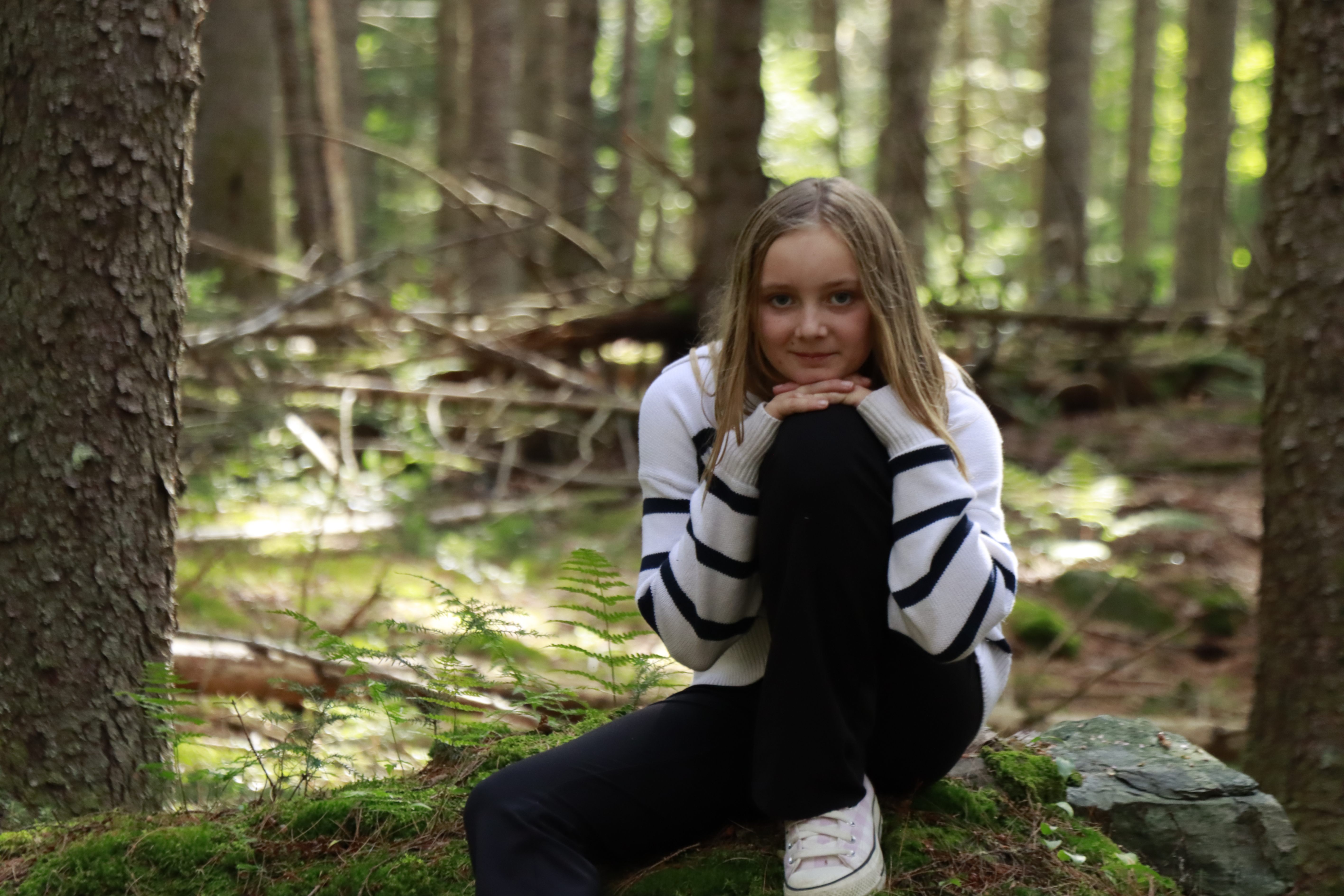 Wolcott student enjoys the mossy woods during a hiking break on the Study Hall Trail