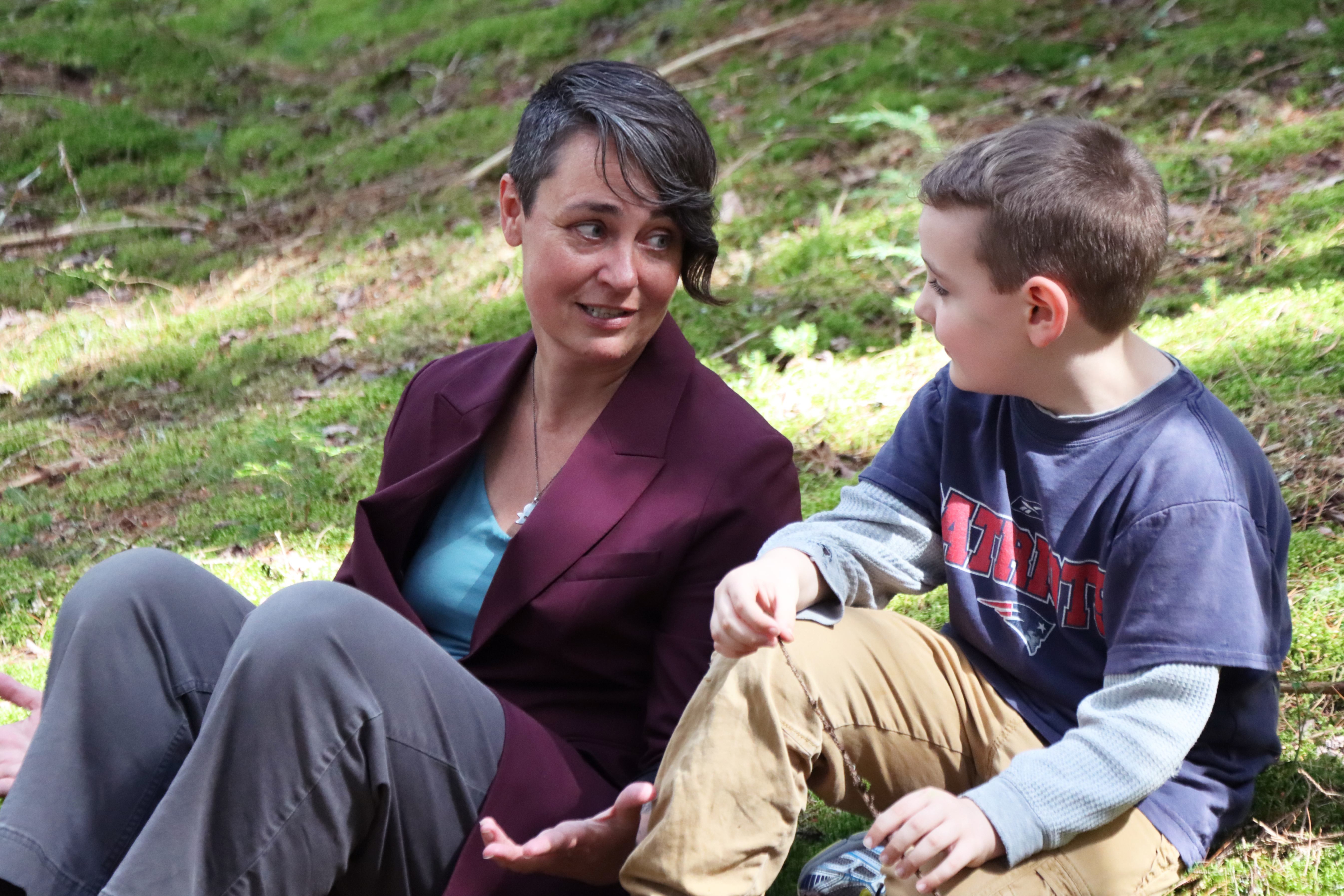Superintendent Rebecca Tatistcheff enjoys conversation with a Wolcott student in the mossy woods