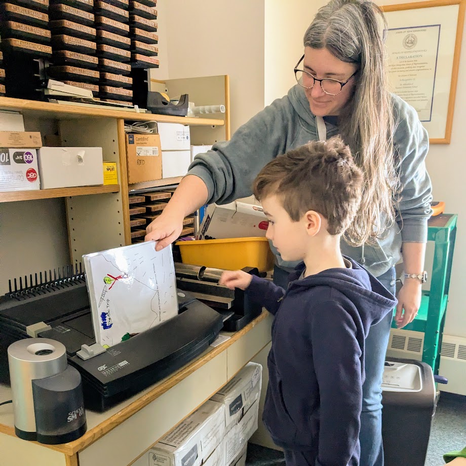 student and teacher binding a book