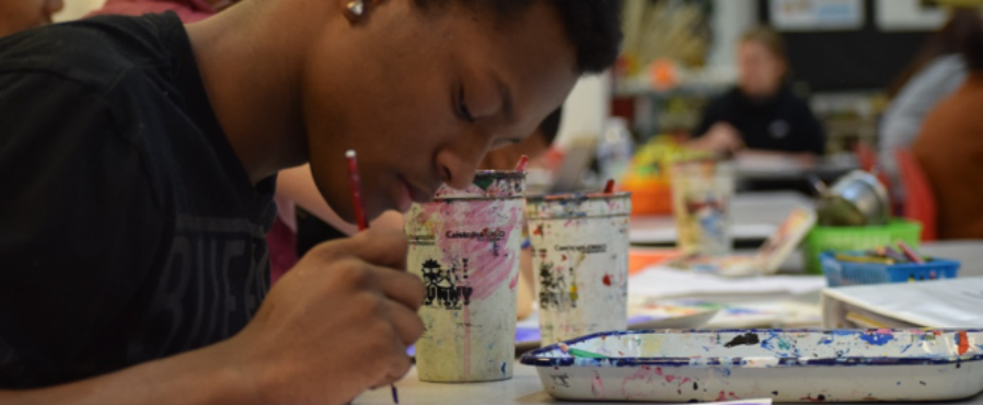 Student painting at a table