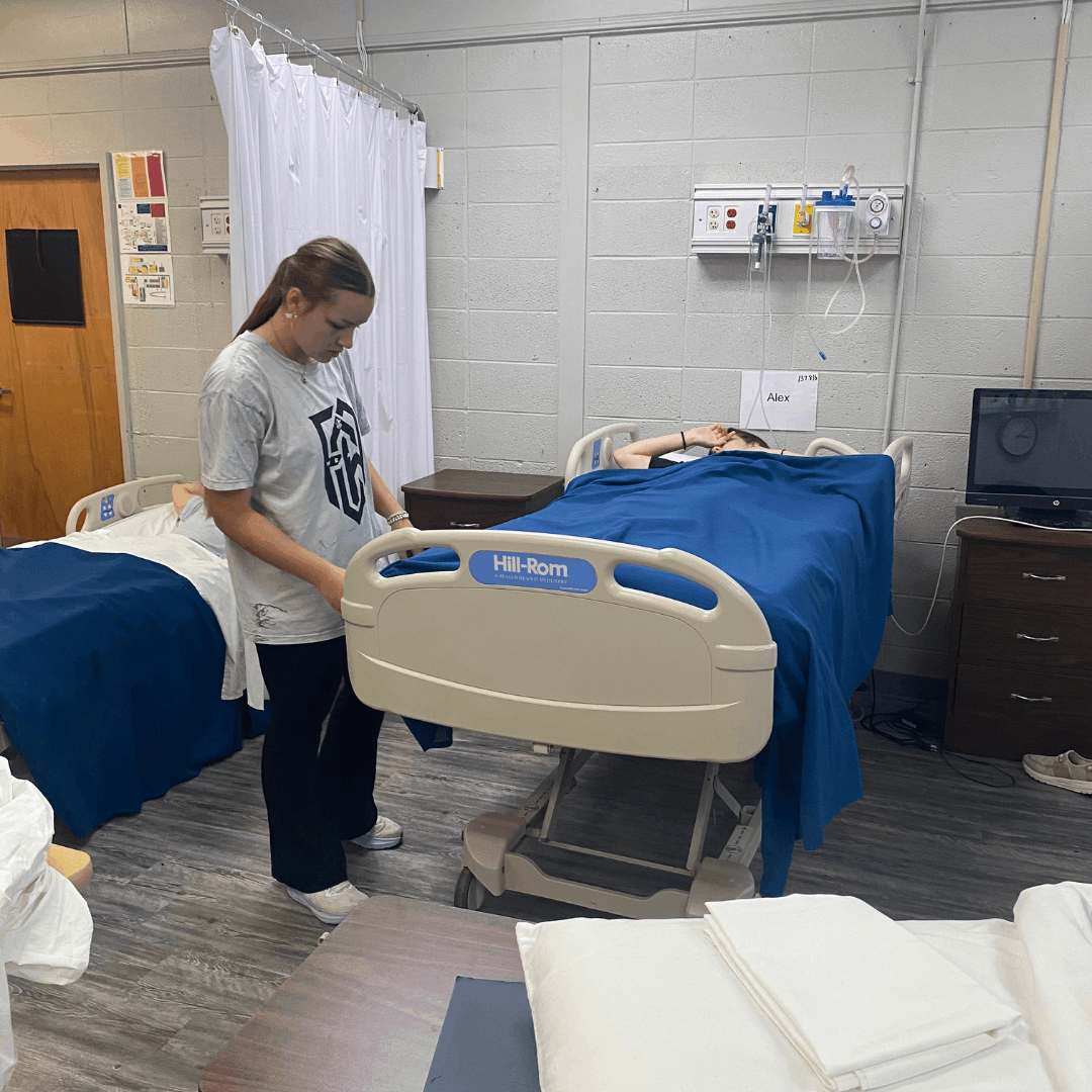 female student standing next to a hospital bed