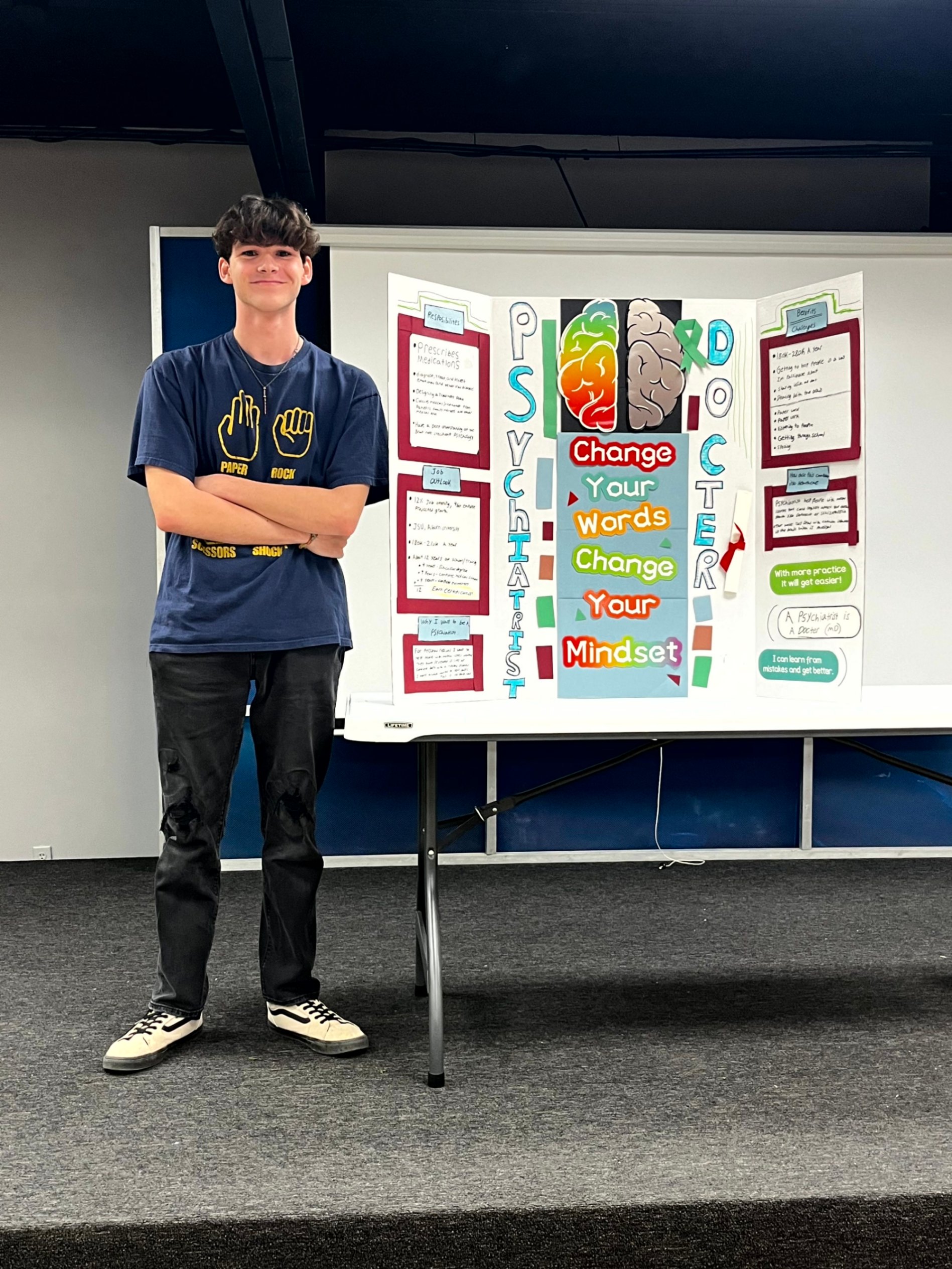STUDENT STANDING WITH THEIR CAREER PRESENTATION BOARD