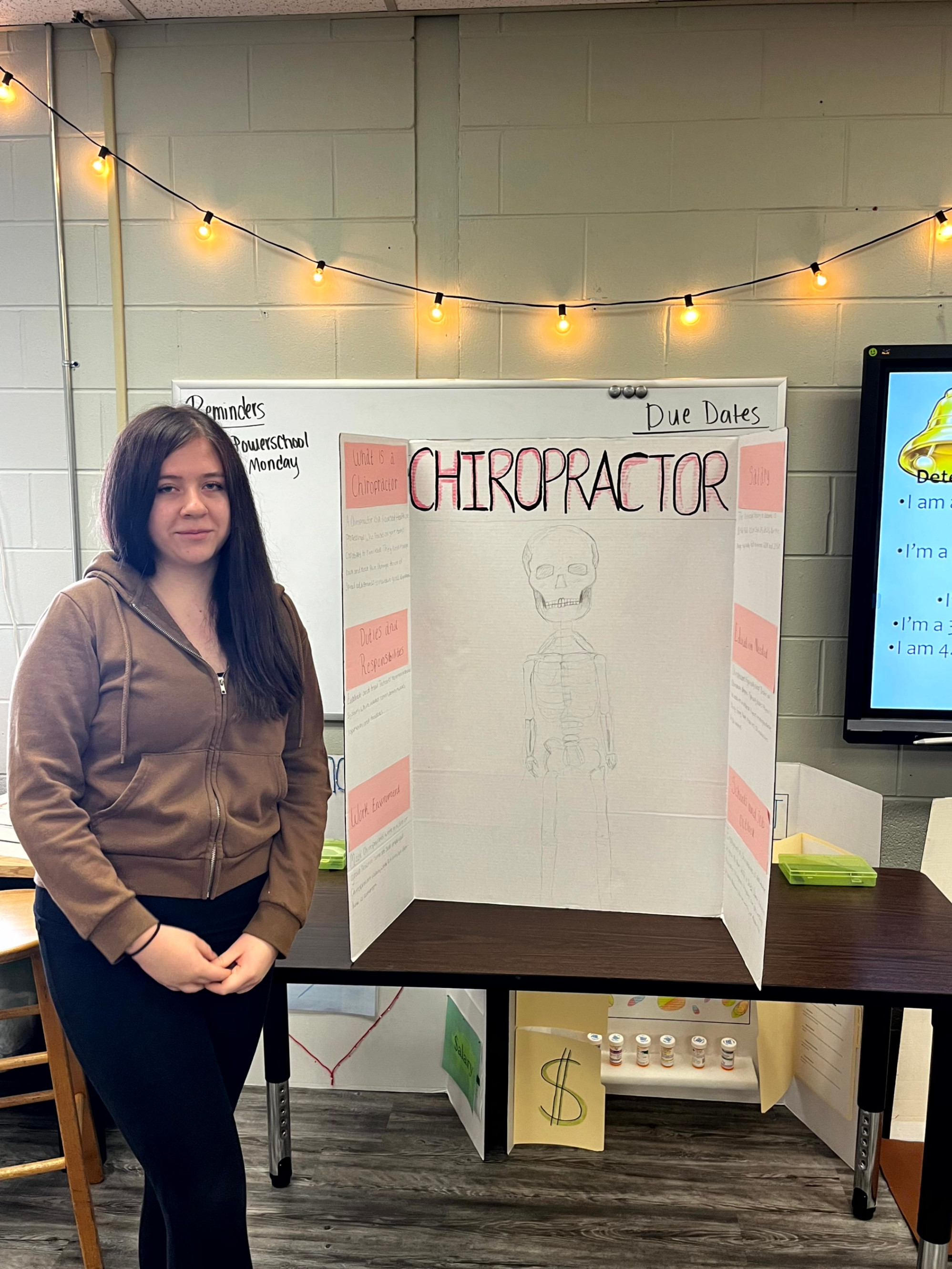STUDENT STANDING WITH THEIR CAREER PRESENTATION BOARD