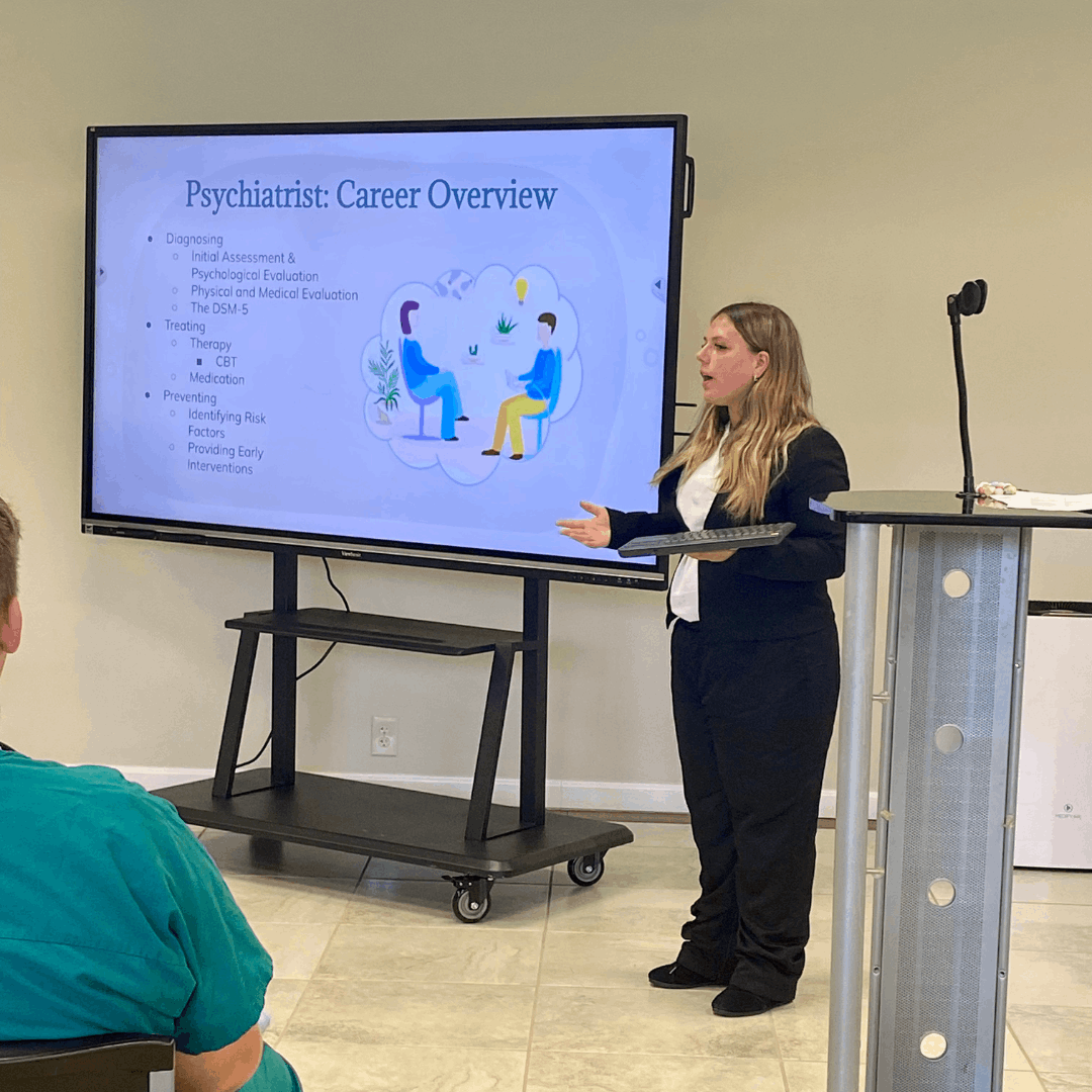 female guest speaker standing on stage presenting careers in healthcare on tv