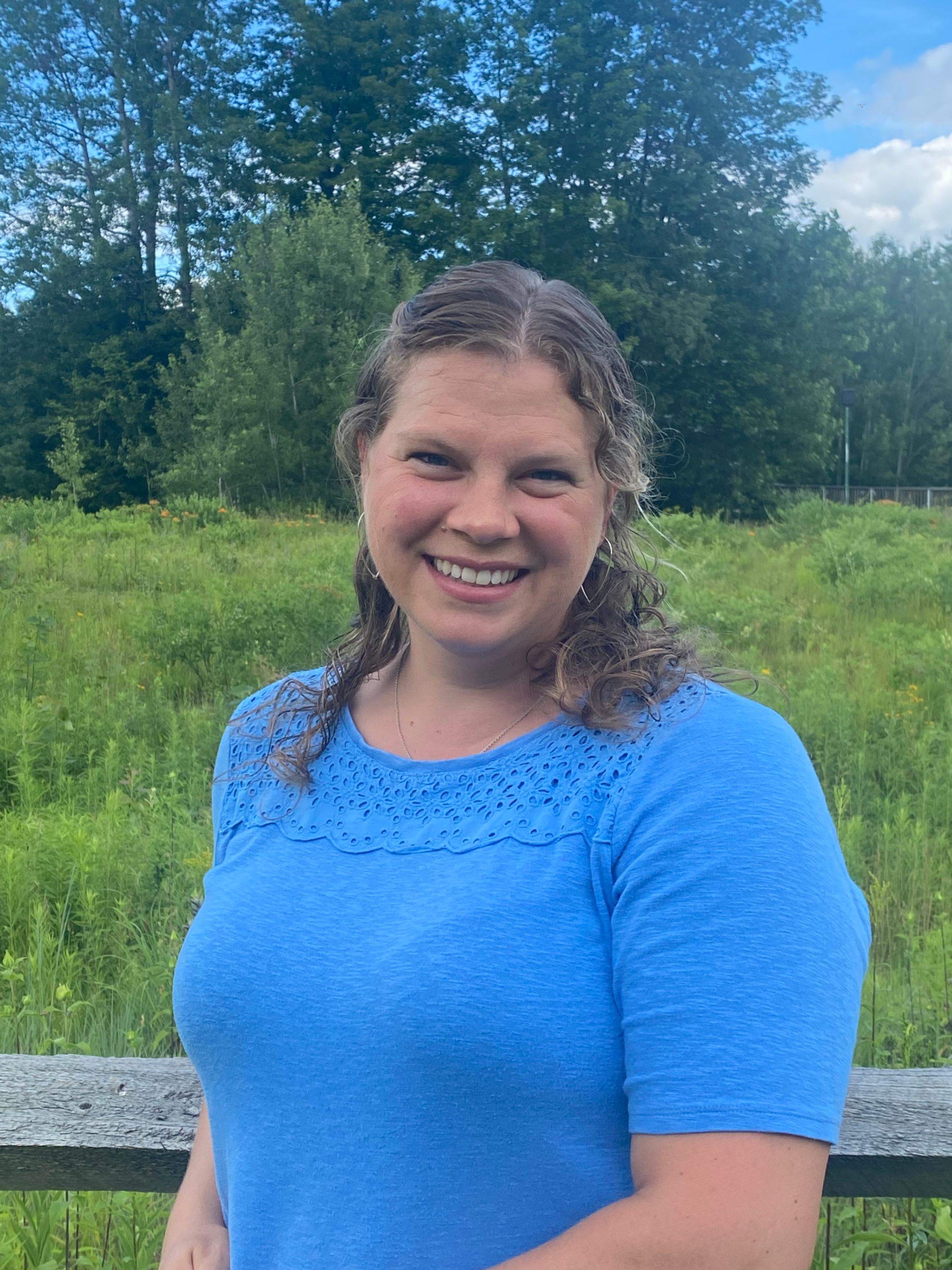 woman in blue shirt in front of field