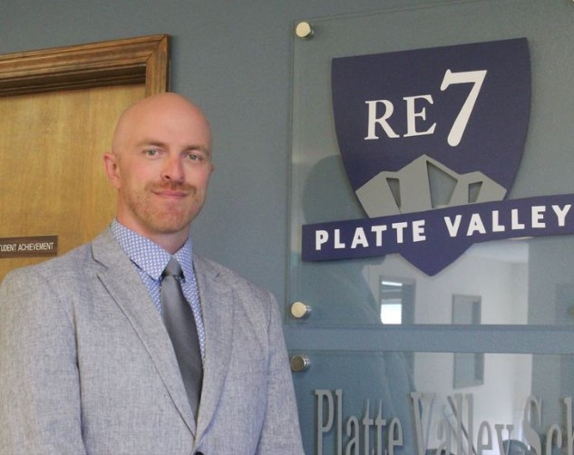 Image of PVHS Principal Eric Lind beside the Platte Valley District logo