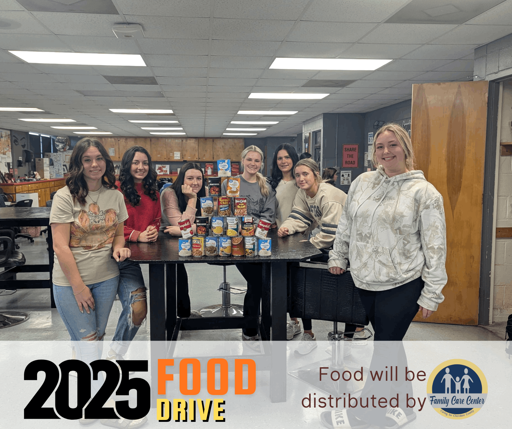 students standing next to canned food collected for the Fall Food Drive