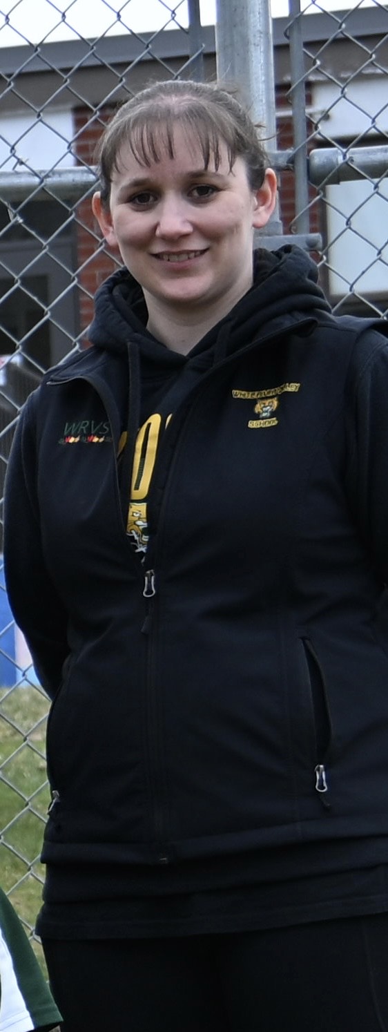 smiling woman with light brown hair in a dark hoodie