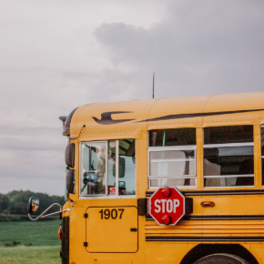 Front of a school bus from side profile view on a cloudy day
