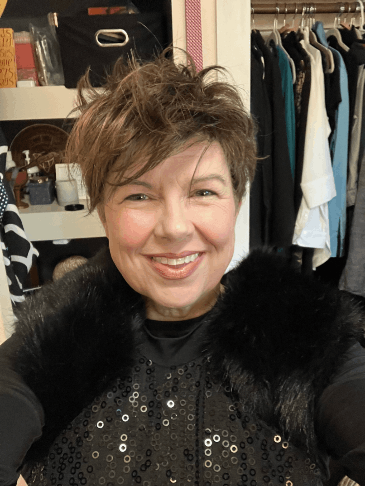 A woman wearing a jean jacket is smiling into the camera.