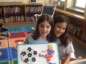 image of two female students holding a school project