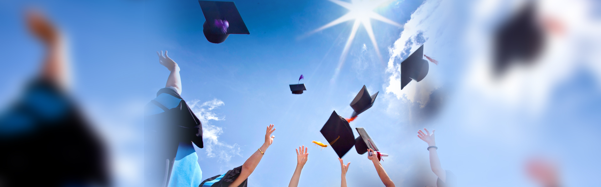 Graduates throwing their mortarboards in the air