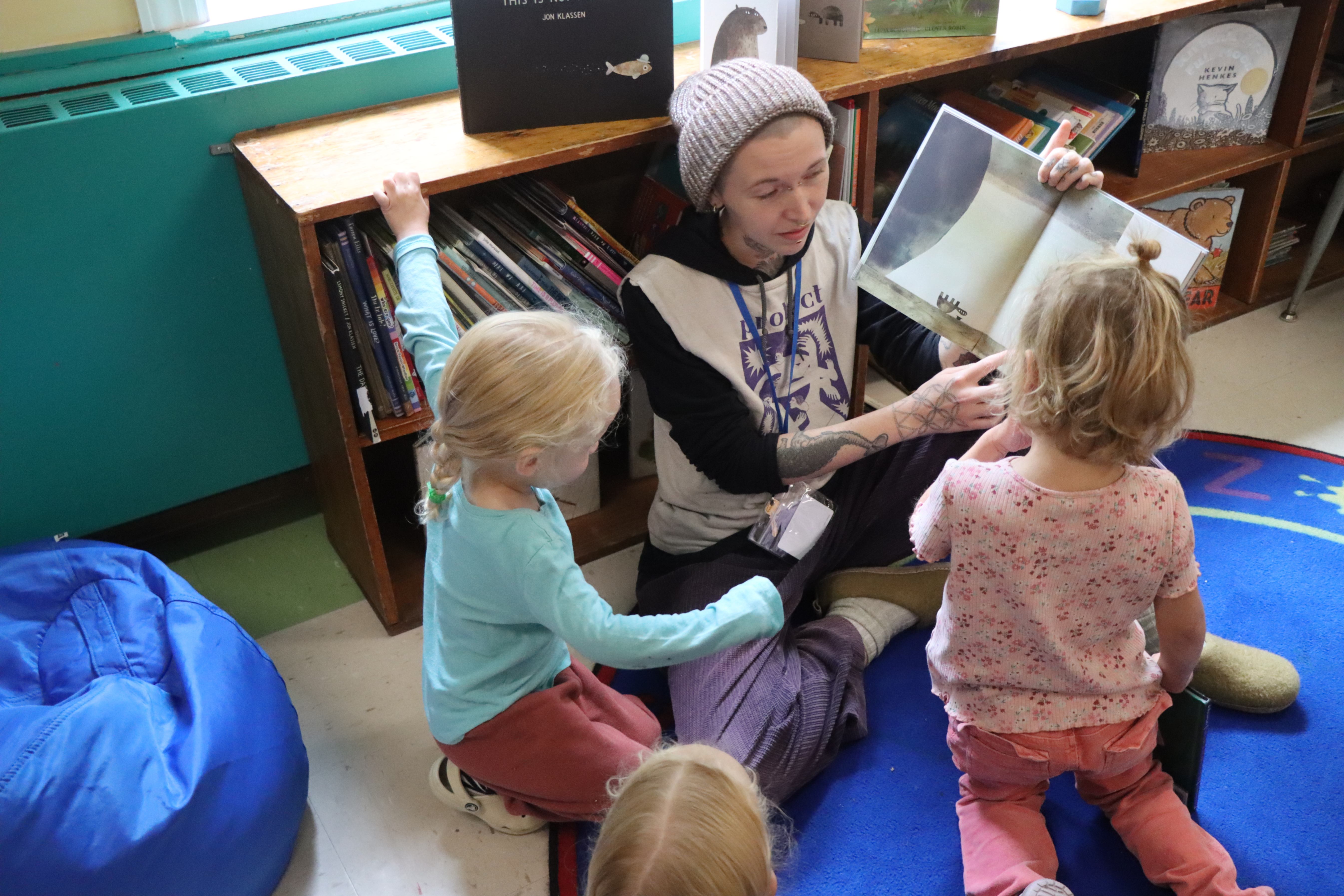 teacher reading to preschool students 
